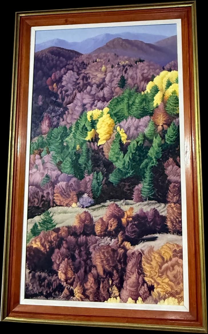 A densely wooded hillside with purple, yellow, green, and rust-coloured trees, in a reddish gold frame